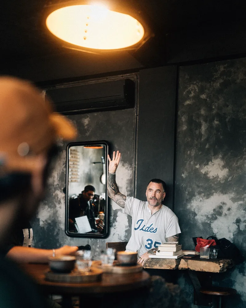 A member photographs Matt mid-gesture during a cafe session